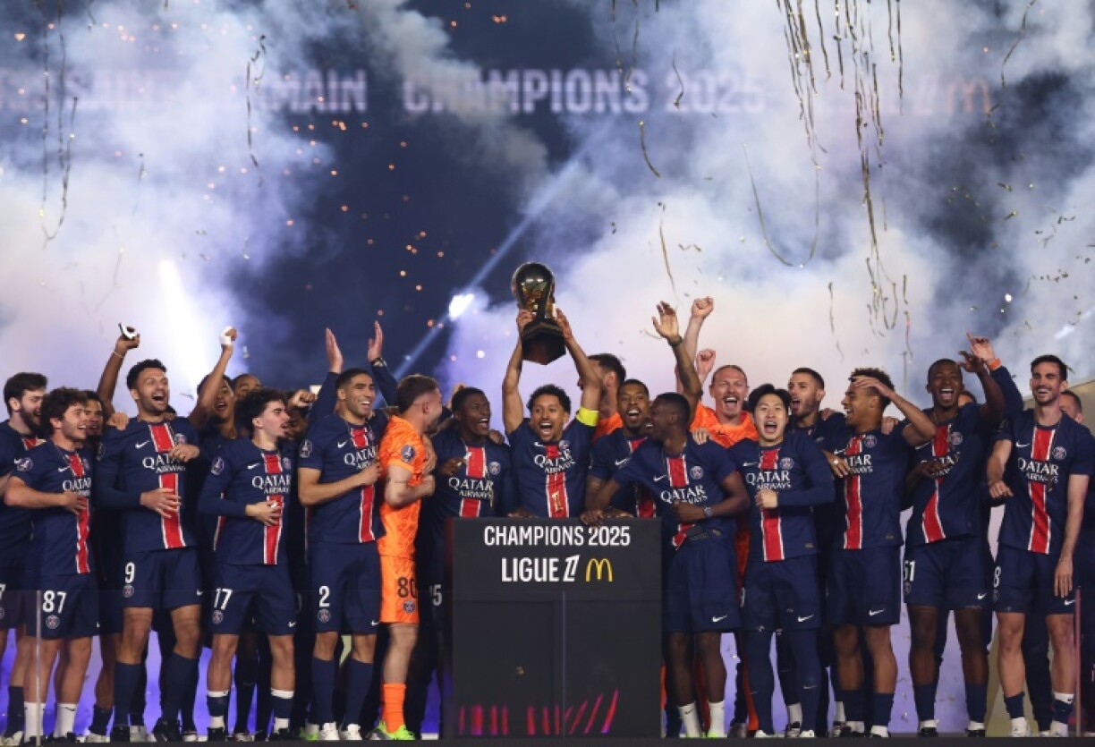 Paris Saint-Germain captain Marquinhos (C) lifts the Ligue 1 championship trophy