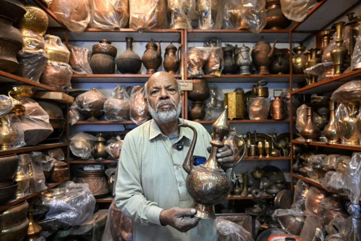 Antique dealer Ahsan Shakeel shows an artefact at his shop selling vintage items in Rawalpindi