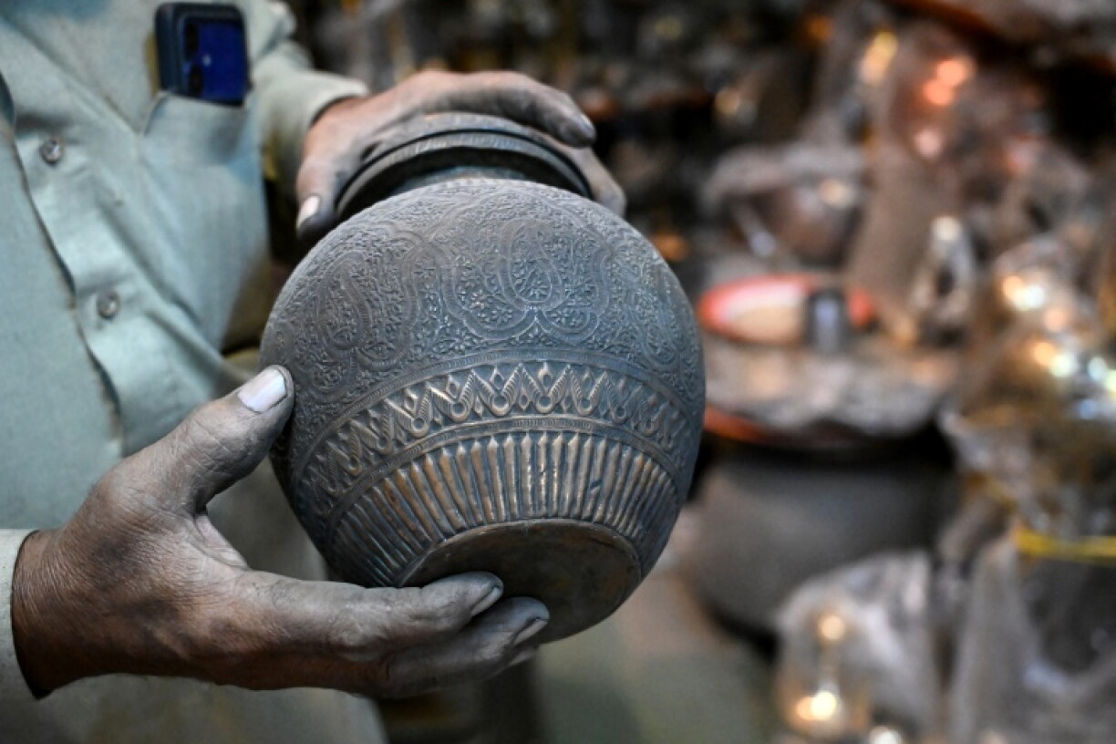 Antique dealer Ahsan Shakeel shows an artefact at his shop selling vintage items in Rawalpindi