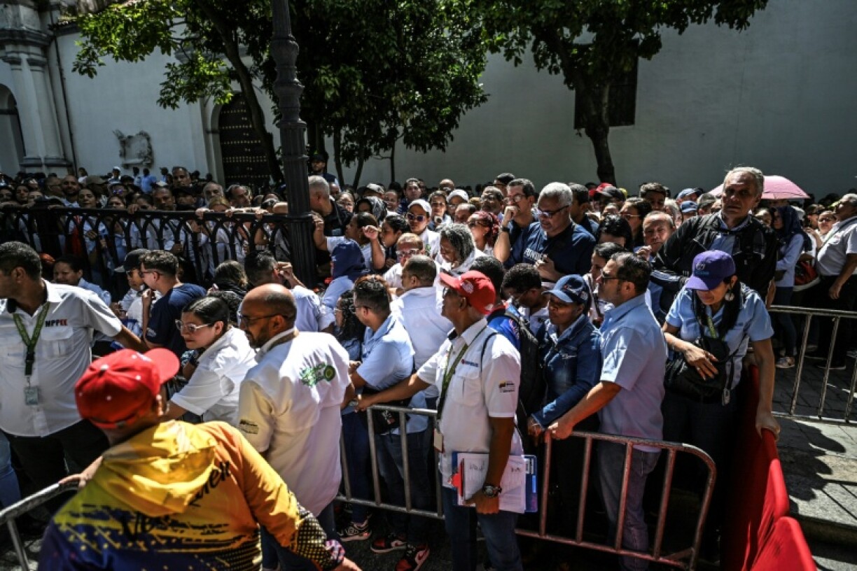 People line up during the Bolivarian militia enlistment process at Bolivar Square in Caracas