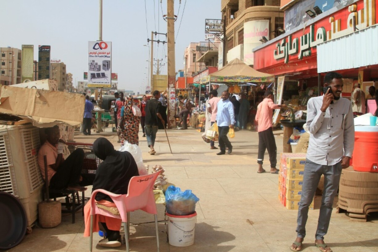 Sudanese walk past shops in Khartoum's twin city Omdurman on July 29, 2025