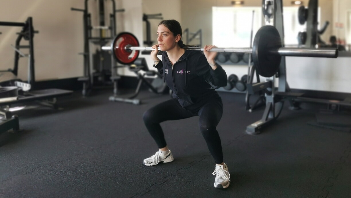 Les squats, réalisés ici avec des poids, constituent un bon exercice polyarticulaire.