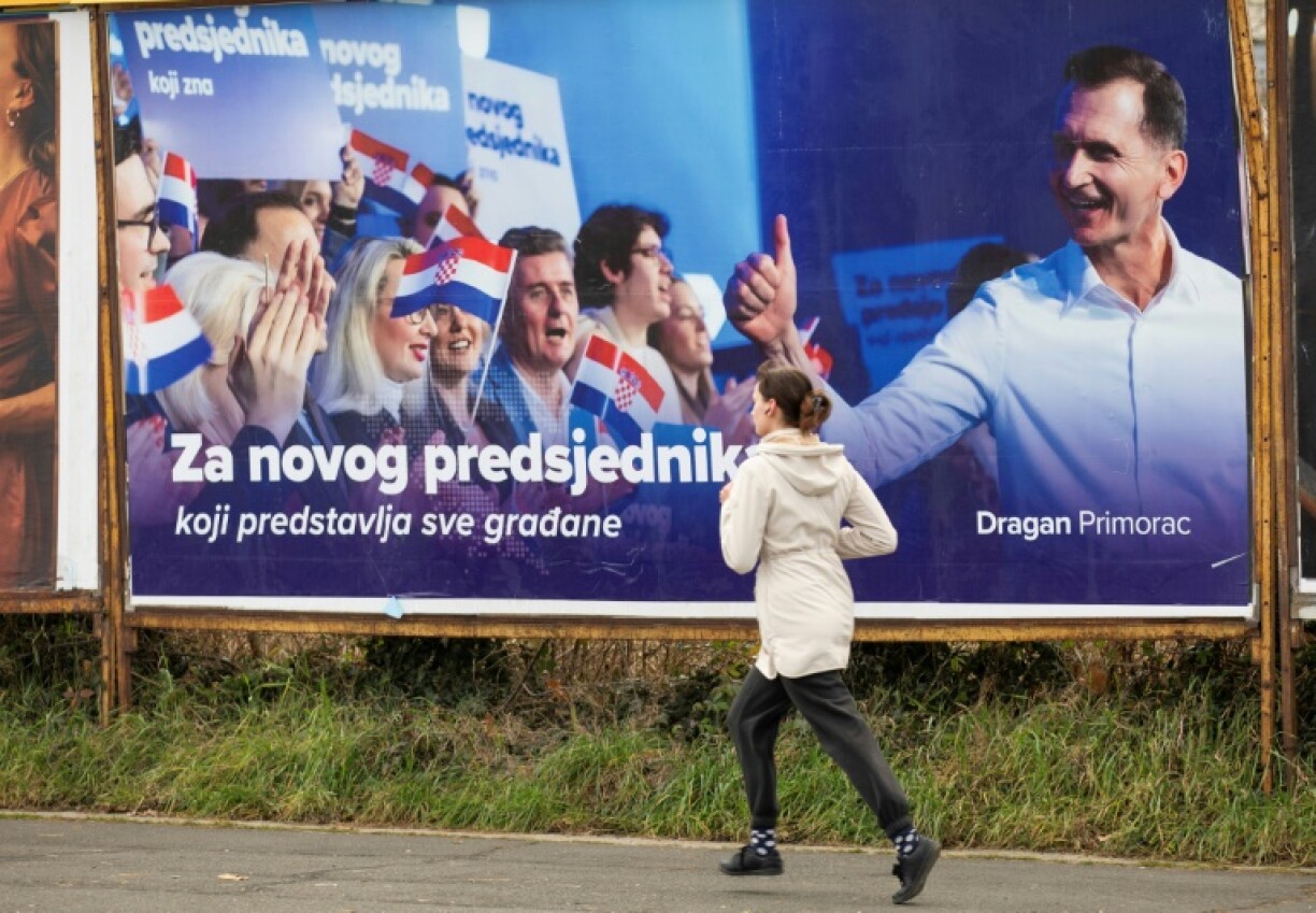 Une femme passe devant une affiche électorale du candidat à la présidentielle du HDZ, Dragan Primorac, le 9 janvier 2025