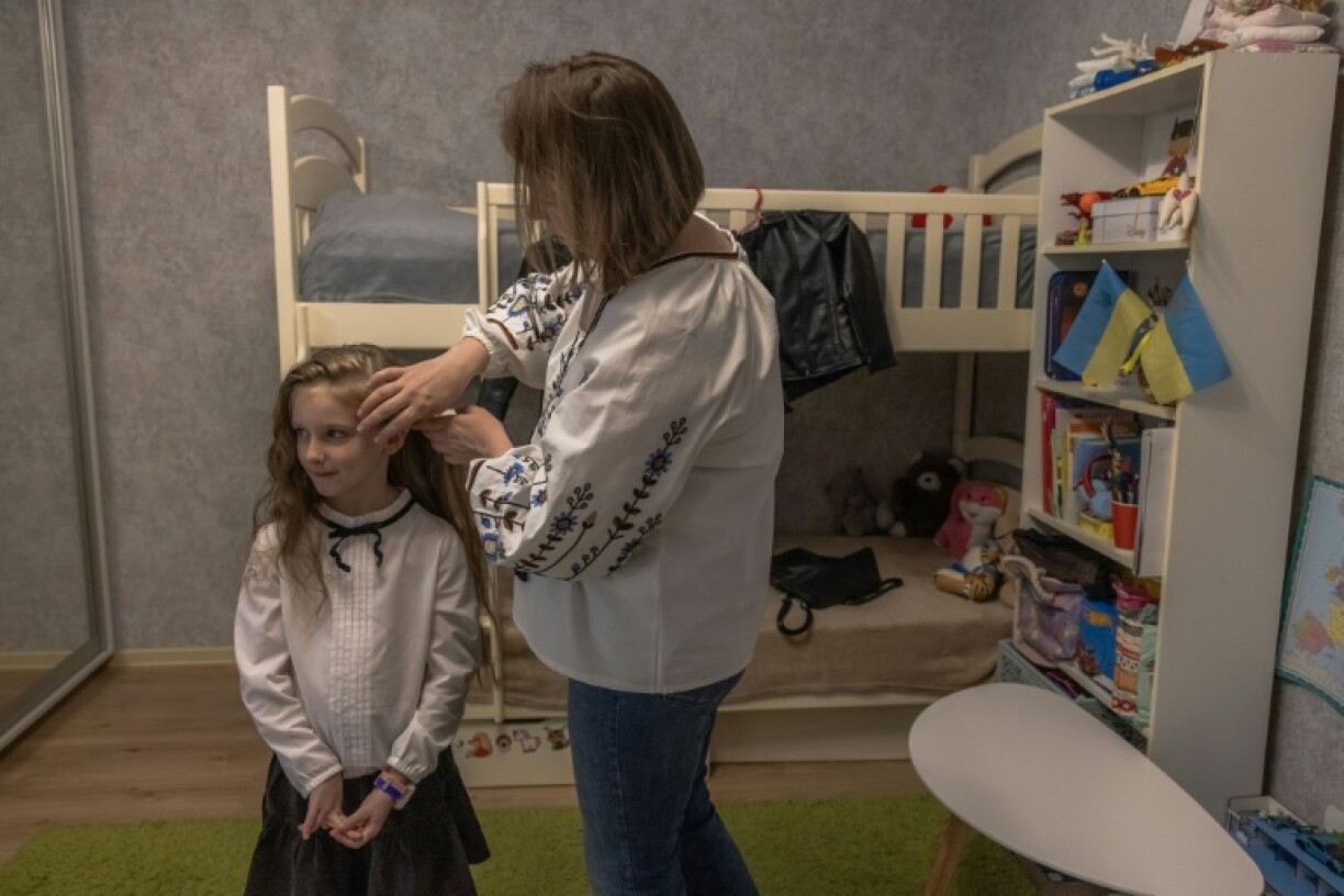 Viktoriya Mikhailyuk prépare sa fille pour la rentrée des classes, le 1er septembre 2023 à Irpin, près de Kiev, en Ukraine