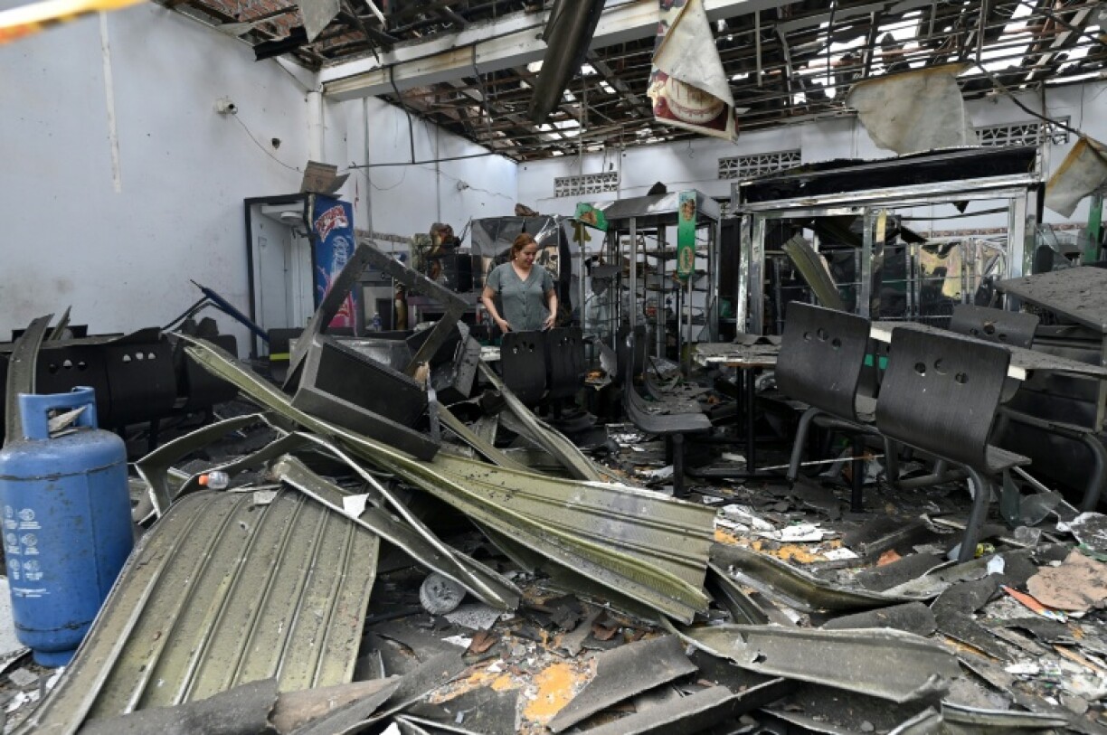A woman stands inside a destroyed commercial building after a car exploded in front of the City Hall in Corinto, Cauca department, Colombia, on June 10, 2025.