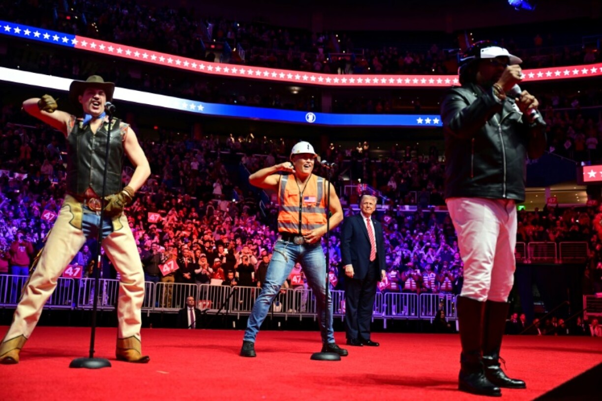 Trump looks on as the Village People perform at the MAGA victory rally at the Capital One Arena in Washington