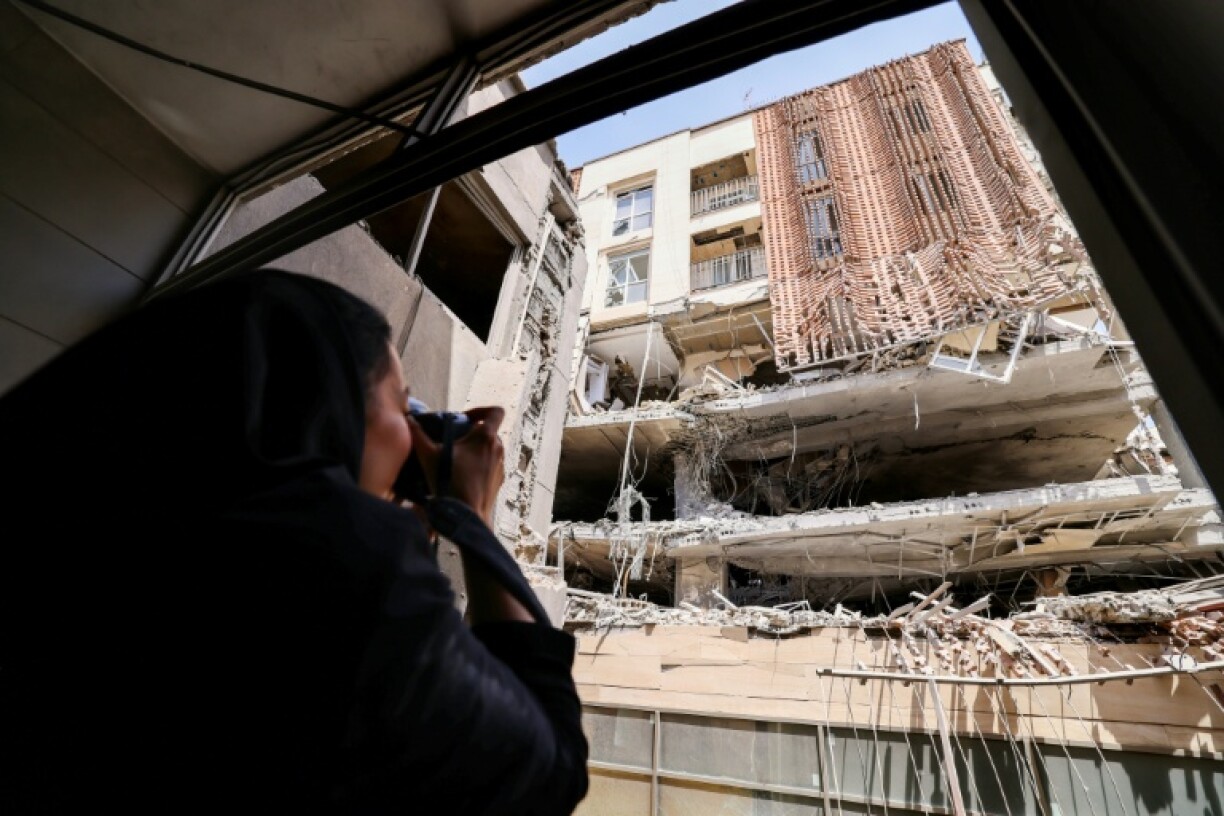 A journalist photographs a residential building that was hit in an Israeli strike, during a government-organised media tour in Tehran
