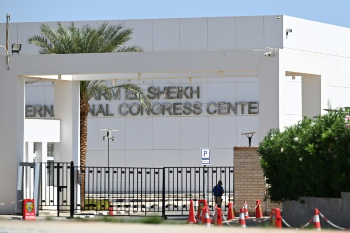 Un homme se tient à l'intérieur du portail du Centre international des congrès à Charm el-Cheikh en Egypte, le 9 octobre 2025, où Israël et le Hamas ont tenu des négociations indirectes ayant abouti à un accord de cessez-le-feu à Gaza