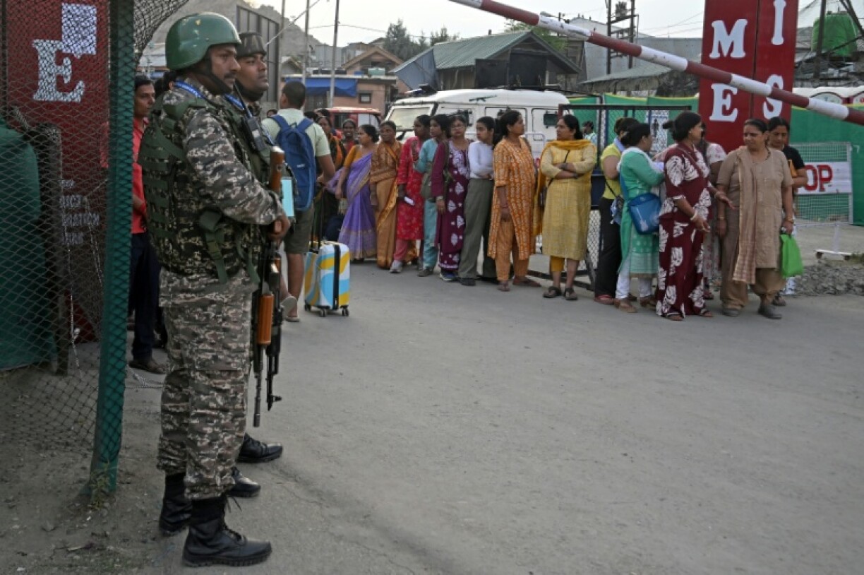 Indian security personnel stand guard as Hindu pilgrims await their registration ahead of the the annual Amarnath pilgrimage