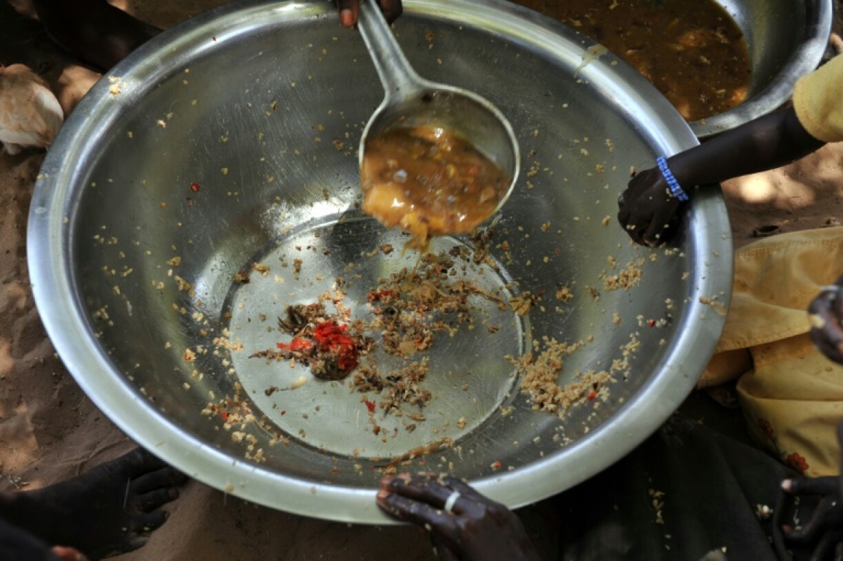 Des mains posées sur une assiette presque vide, servie à des familles dans le village de Merine Dakhar (Sénégal), le 29 mai 2008