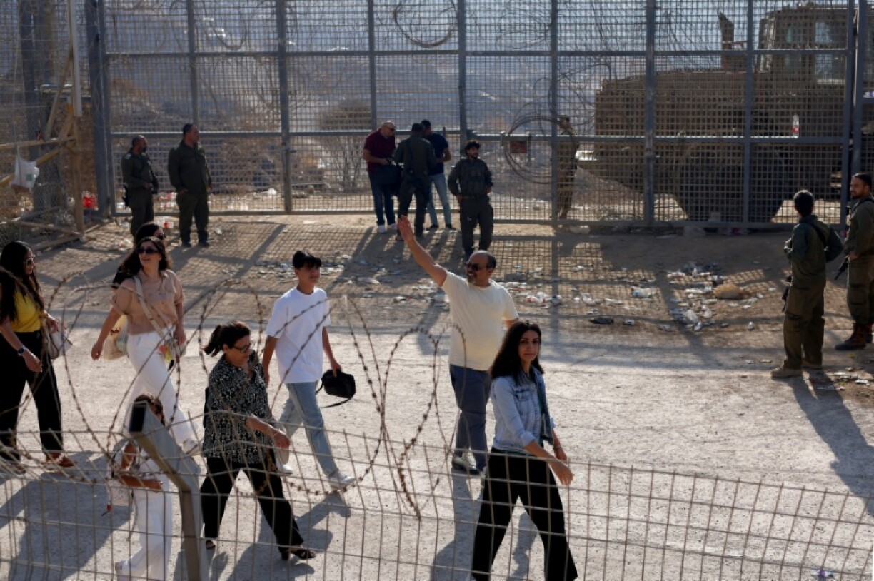 Israeli troops look on as Syrian Druze cross into the Israeli-annexed Golan Heights.