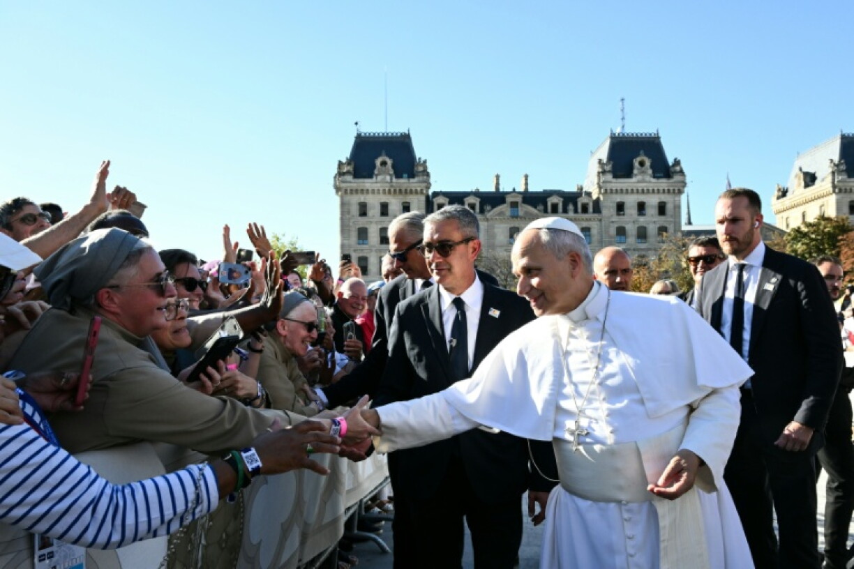 People rushed forward to kiss the hand of the pope as he arrive at Notre Dame cathedral