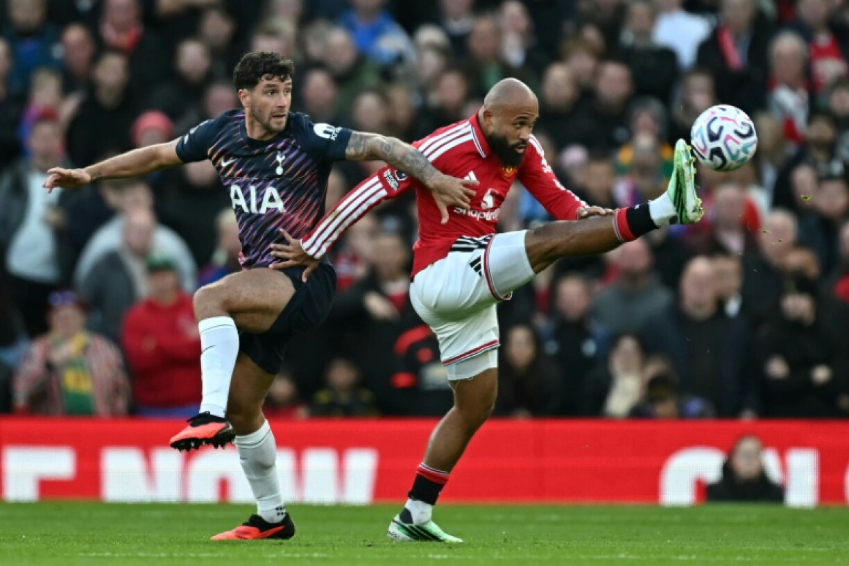 Manchester United striker Bryan Mbeumo (R) wins a duel with Tottenham Hotspur defender Marcos Senesi at Old Trafford.