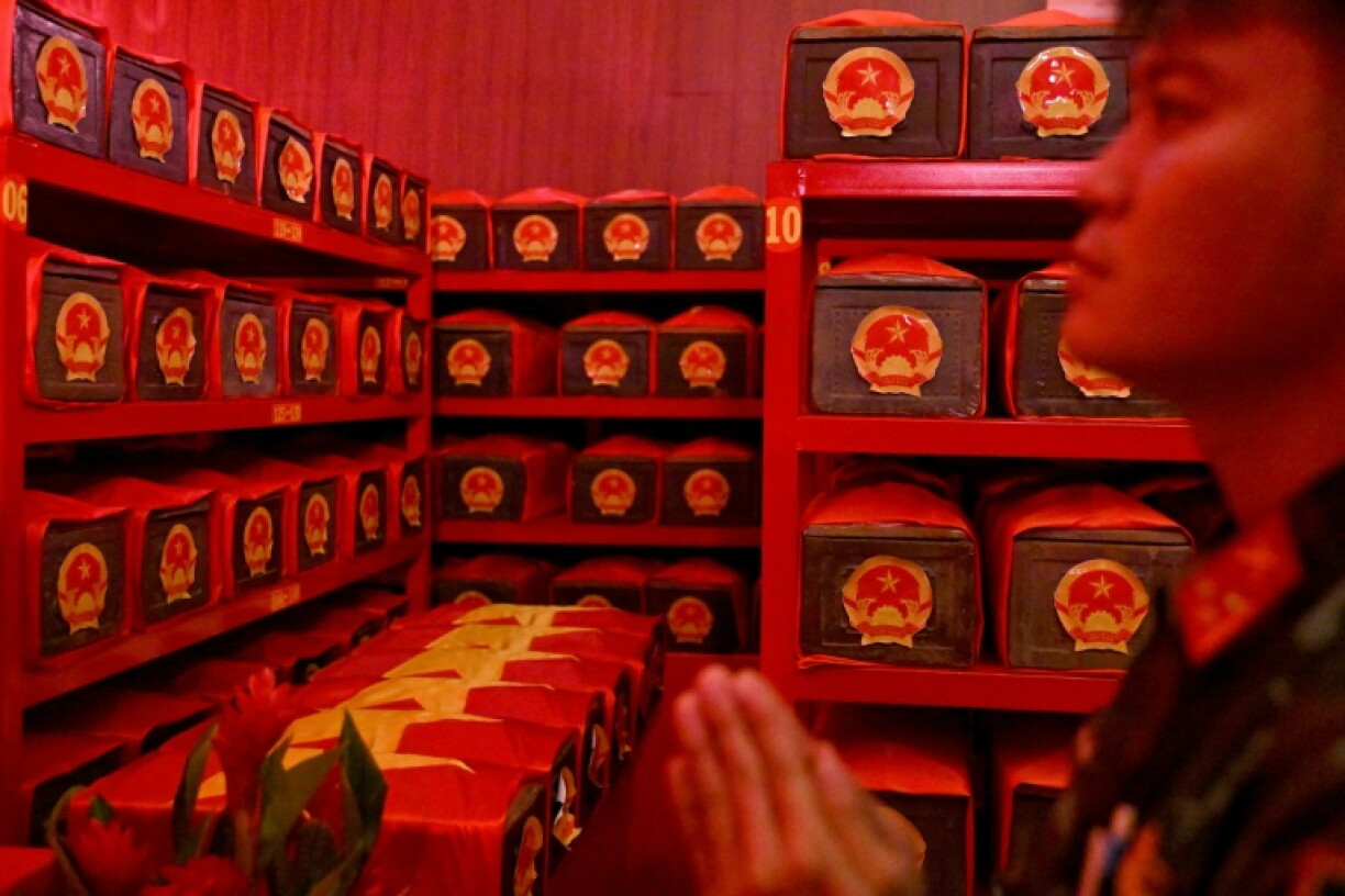 A soldier stands in prayer inside a room housing the remains of fallen soldiers at Le Thi Rieng Park in Ho Chi Minh City