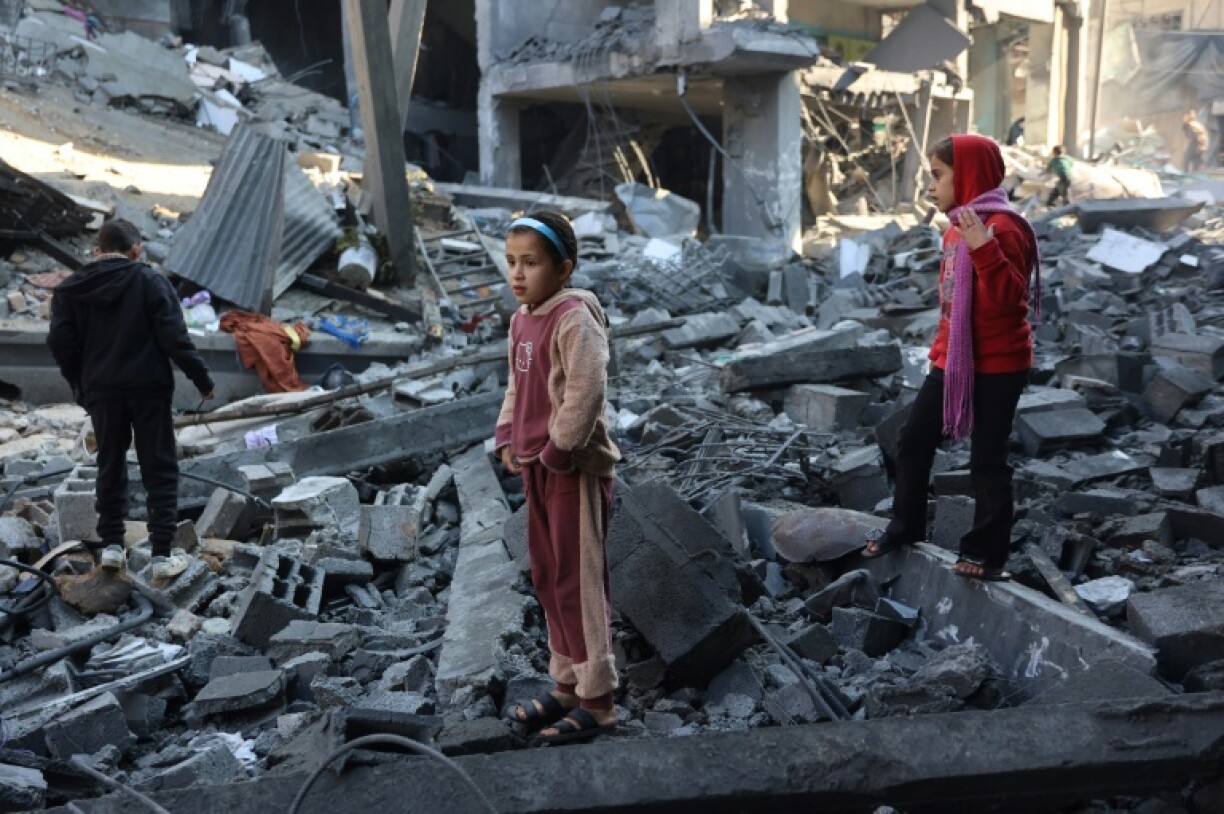 Palestinian children inspect damage after an Israeli strike in Jabalia, in the north of Gaza where several displaced Gazans said they also fear falling temperatures and heavy rains