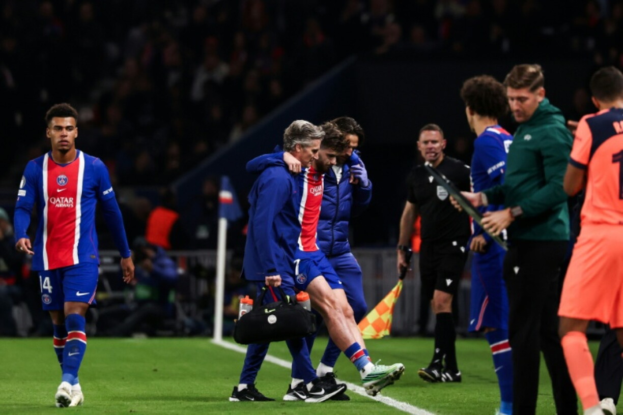 Khvicha Kvaratskhelia is helped off the pitch during PSG's game against Barcelona on Tuesday