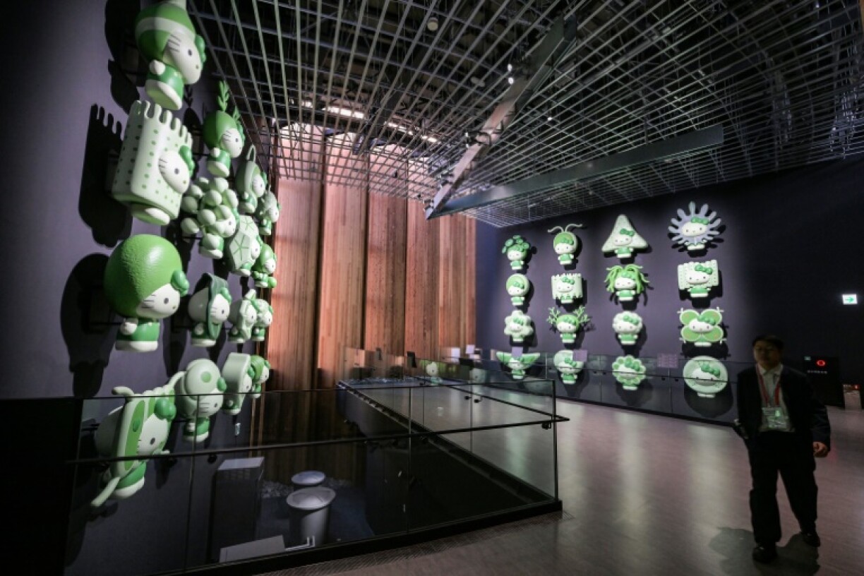 A visitor walks past a Hello Kitty display with different types of algae, at the Japan pavilion