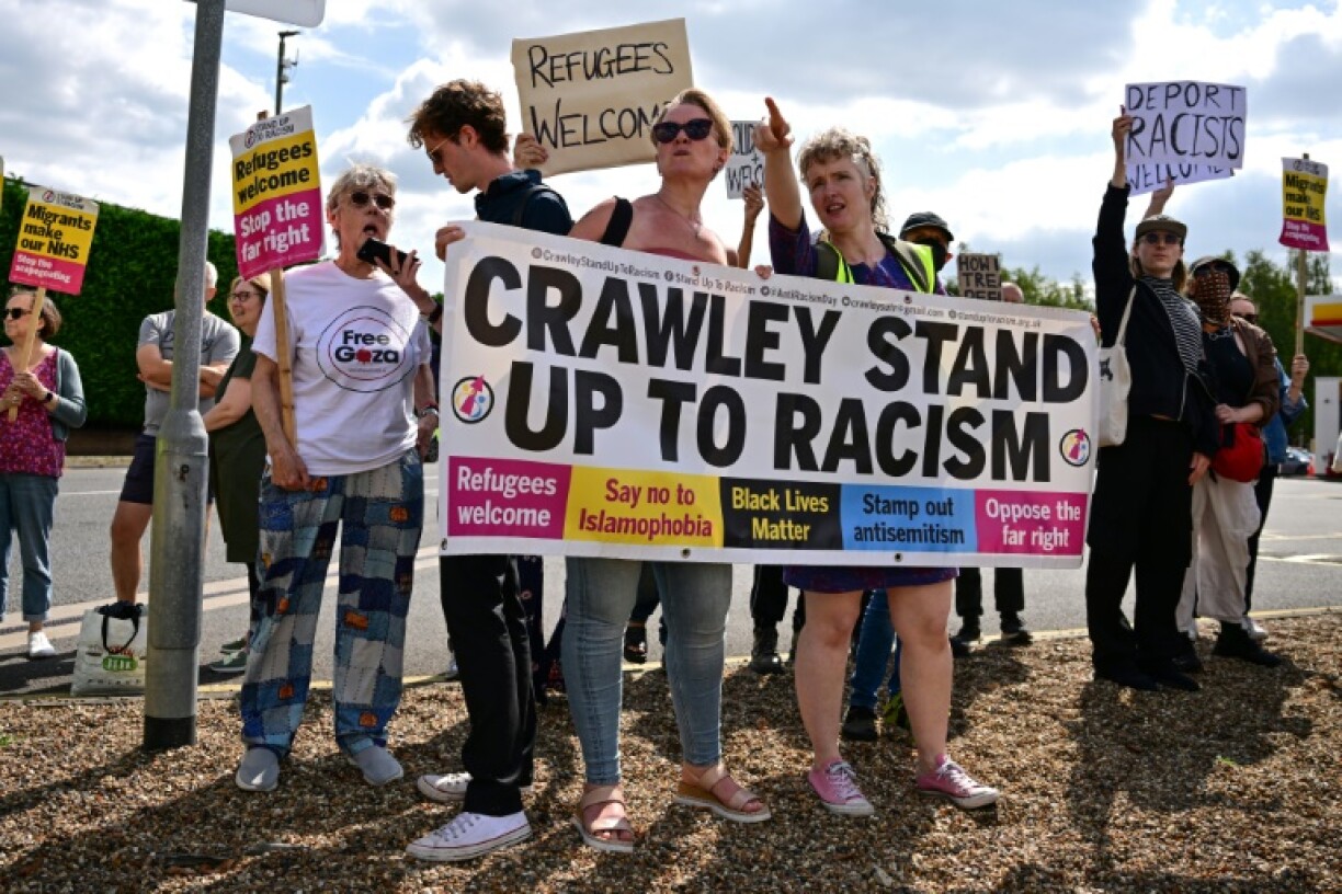 Counter-protestors hold a banner outside a hotel believed to be housing asylum seekers, south of London