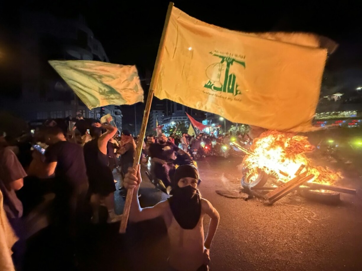 Supporters of Lebanon's Hezbollah militant group block the streets in Beirut with burning tires as they rally in cars and motorbikes to protest the government's endorsement of a plan to disarm it