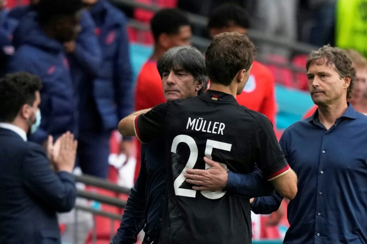 Le sélectionneur allemand Joachim Loew réconforte l'attaquant Thomas Mueller, après la défaite, 2-0 face à l'Angleterre, en 8e de finale de l’Euro 2020, le 29 juin 2021 au stade de Wembley à Londres