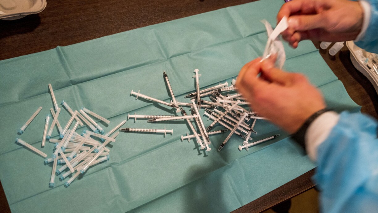 A medical worker prepares a syringe with a vaccine against the novel coronavirus COVID-19 in Frankfurt am Main on November 23, 2021 during an event where people in need are offered the vaccination and a meal.
