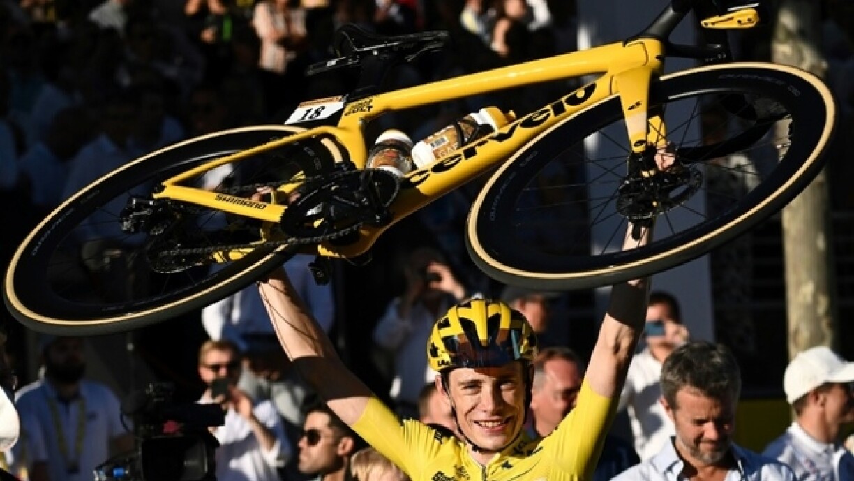 Jonas Vingegaard soulevant triomphalement son vélo après sa victoire.