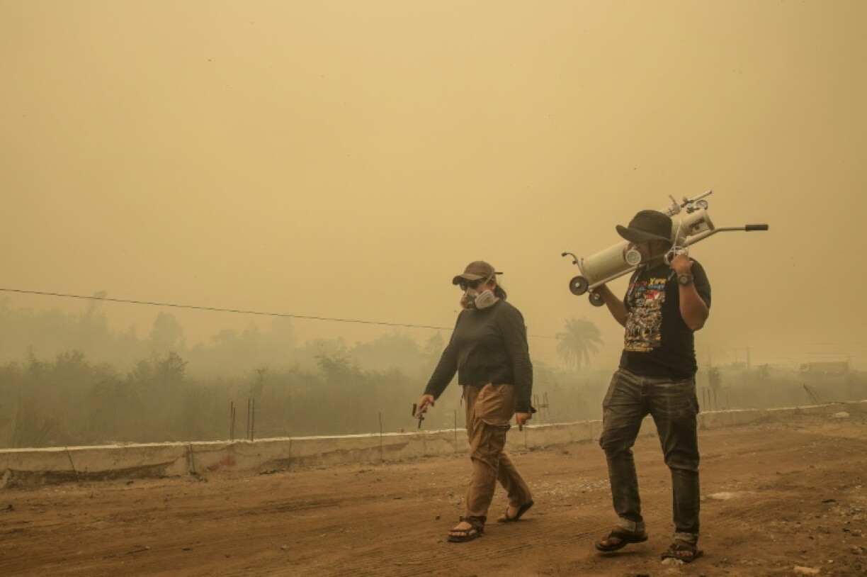 Government workers and volunteers bring portable oxygen tanks to those in need