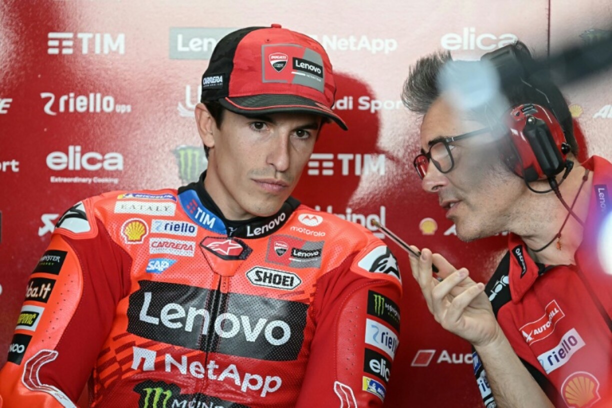 Marc Marquez (L) consults with a Ducati team member at Buriram