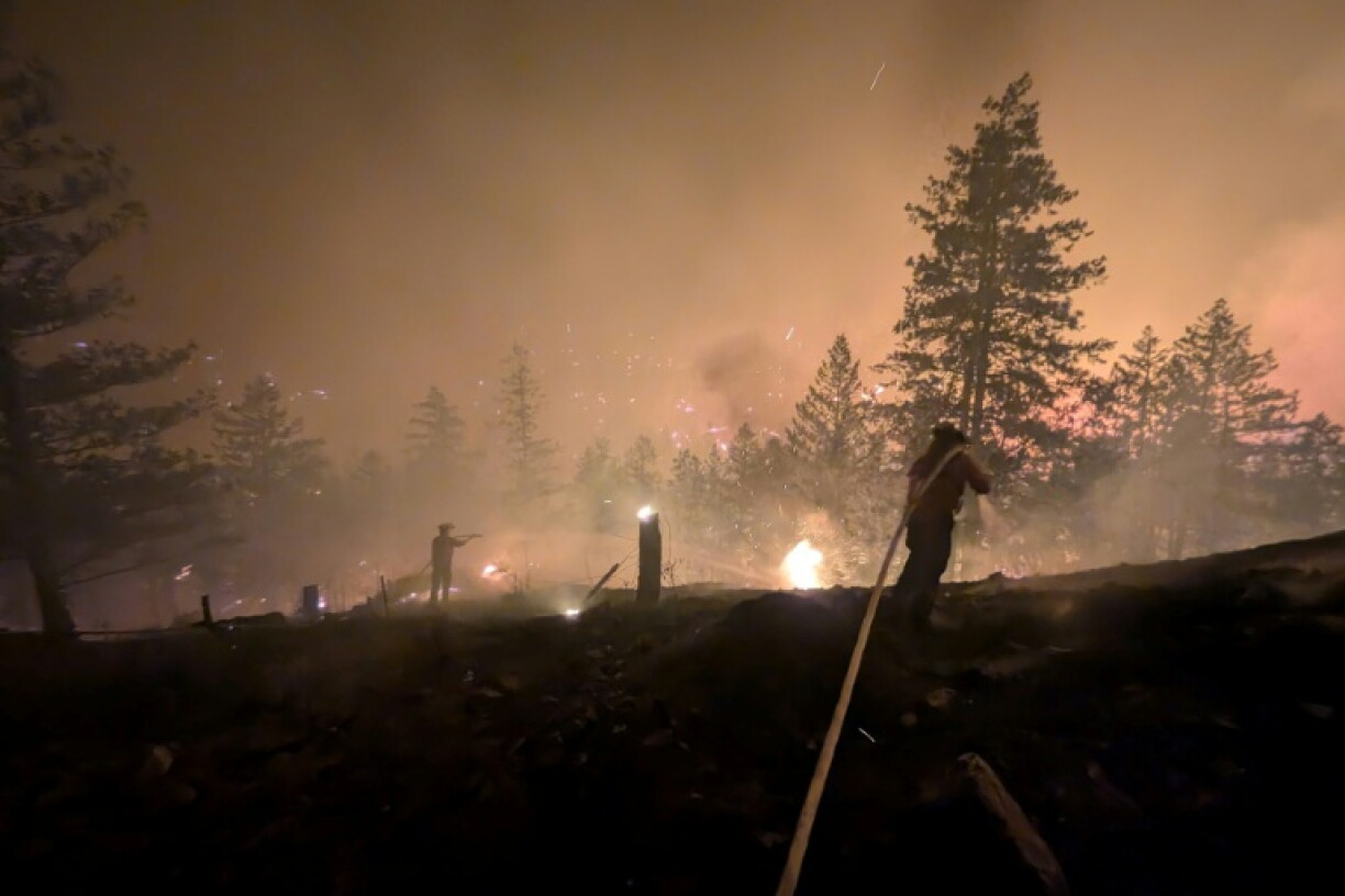 Photo prise le 7 août 2026 et diffusée le lendemain par le Service canadien de la faune de Colombie-Britannique montrant des pompiers luttant contre un incendie de forêt près de Summerland, dans l’ouest du Canada