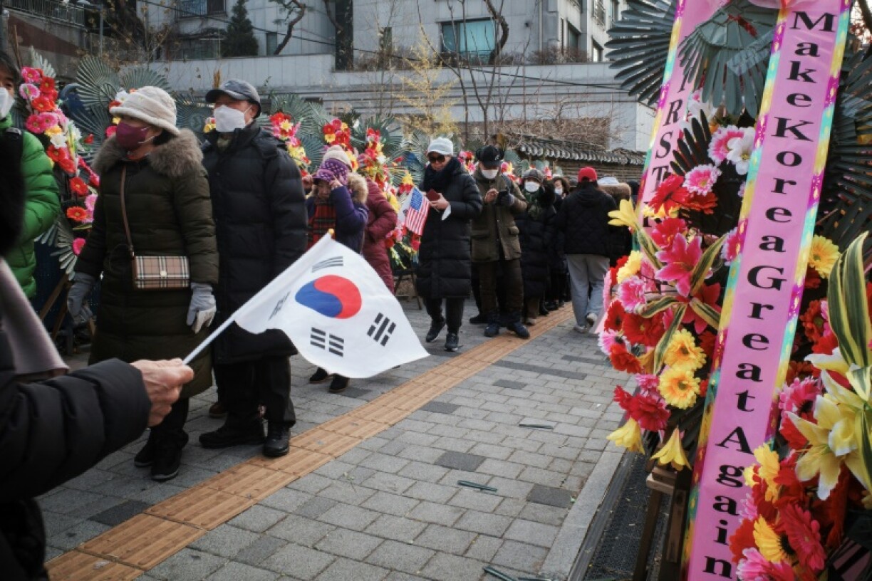 Supporters of impeached South Korean president Yoon Suk Yeol queue up for food outside his home