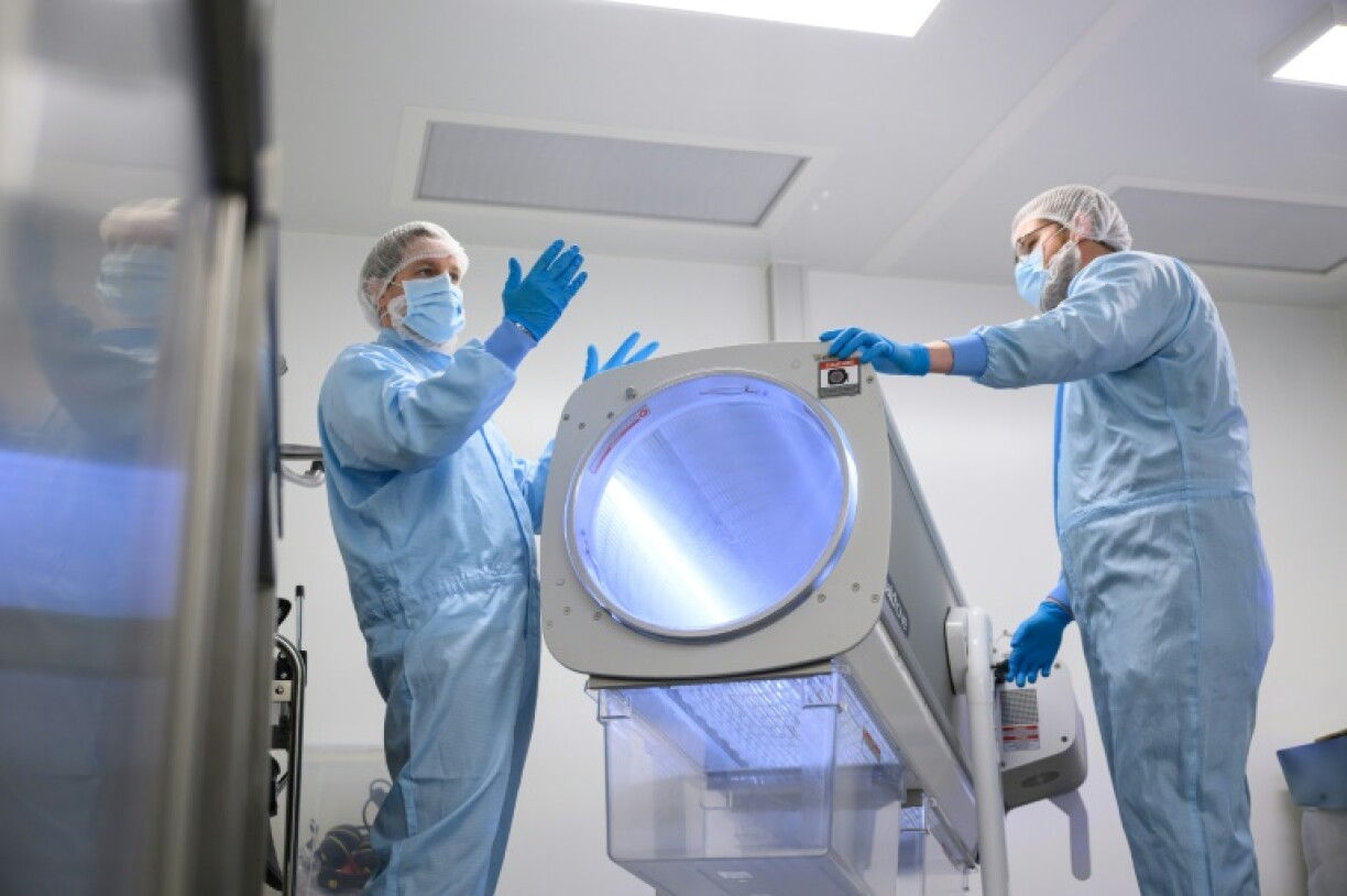 Staff show a specialized device for processing the raw cannabis flowers