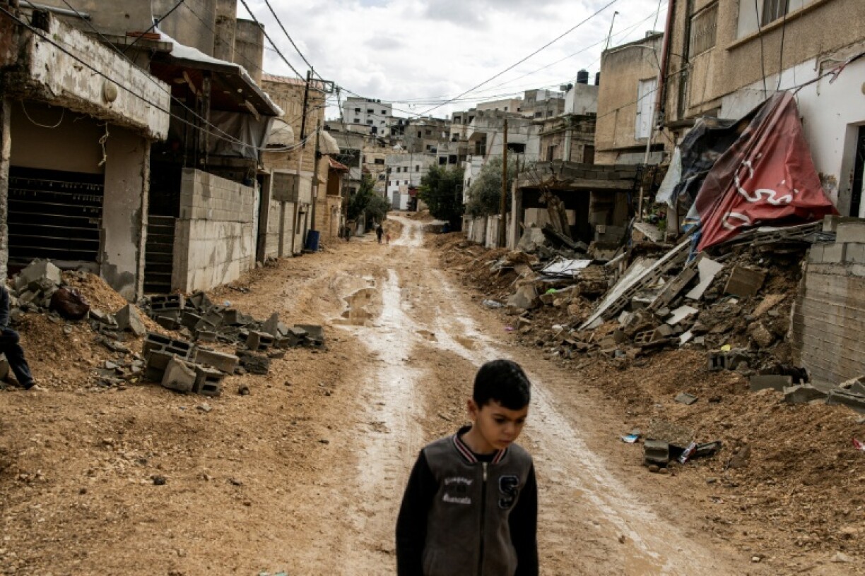 A Palestinian boy walks down a road in east Jenin destroyed by Israeli forces