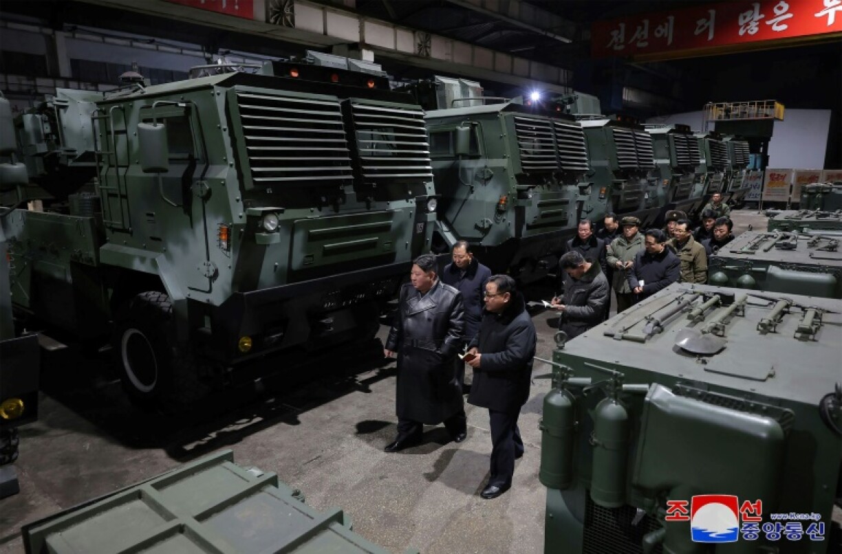 Photo non datée diffusée par l'agence nord-coréenne Kcna le 10 janvier 2024 montrant le dirigeant nord-coréen Kim Jong Un (g) inspectant une importante usine de munitions et d'armements dans un lieu non précisé