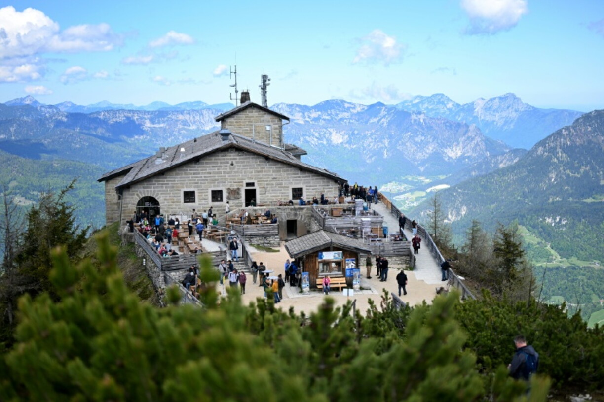 Photo prise le 11 mai 2025 montrant des touristes assis sur la terrasse de la maison d’hôtes de montagne Kehlsteinhaus, qui fut le refuge de montagne d’Adolf Hitler, connu sous le nom de Nid d’aigle, perché dans les montagnes au-dessus de Berchtesgaden, dans le Land de Bavière, au sud de l’Allemagne.