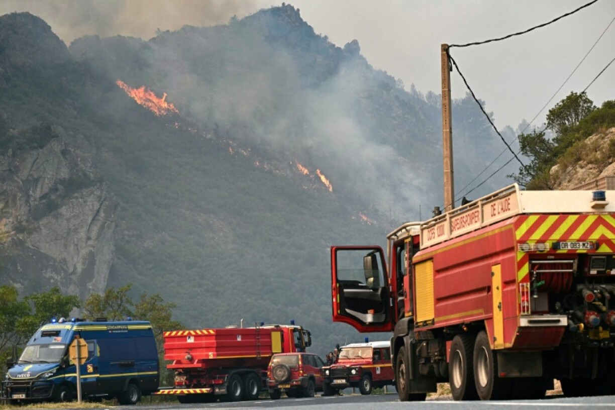 Des camions de pompiers stationnés devant un incendie de forêt près de Fraissé-des-Corbières, le 6 août 2025