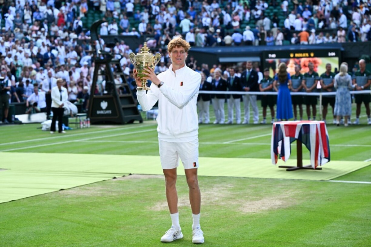 Italy's Jannik Sinner celebrates with the winner's trophy after beating Carlos Alcaraz in the Wimbledon final