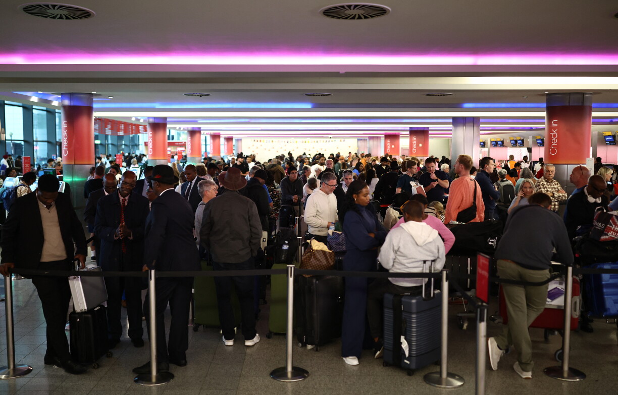 Des passagers retardés attendent et font la queue avec leurs bagages au terminal 3 de l'aéroport de Londres Heathrow.