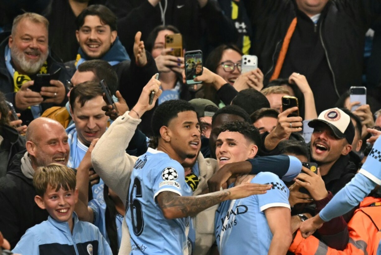 Manchester City midfielder Phil Foden is mobbed by team-mates after scoring his side's first goal during a 4-1 Champions League win over Borussia Dortmund at the Etihad Stadium