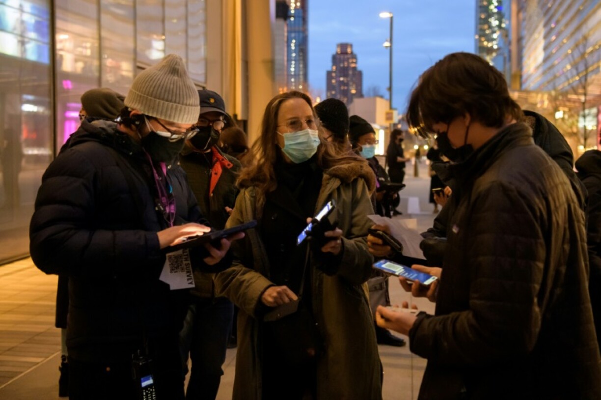 Caroline Baron, au centre, montre le certificat de vaccination sur son téléphone portable, avant d'assister à un concert au