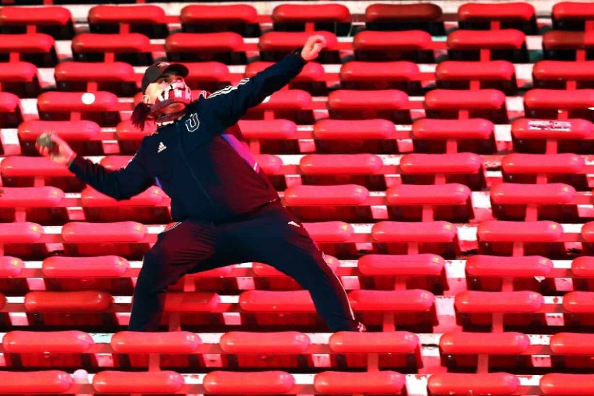 A fan of Universidad de Chile prepares to throw a stone inside the stadium