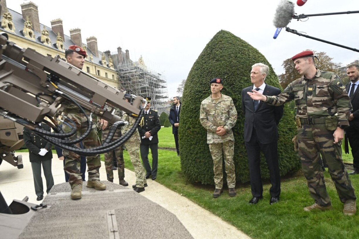 Le roi Philippe de Belgique avec des représentants de l'armée française et belge à l'Hôtel des Invalides.