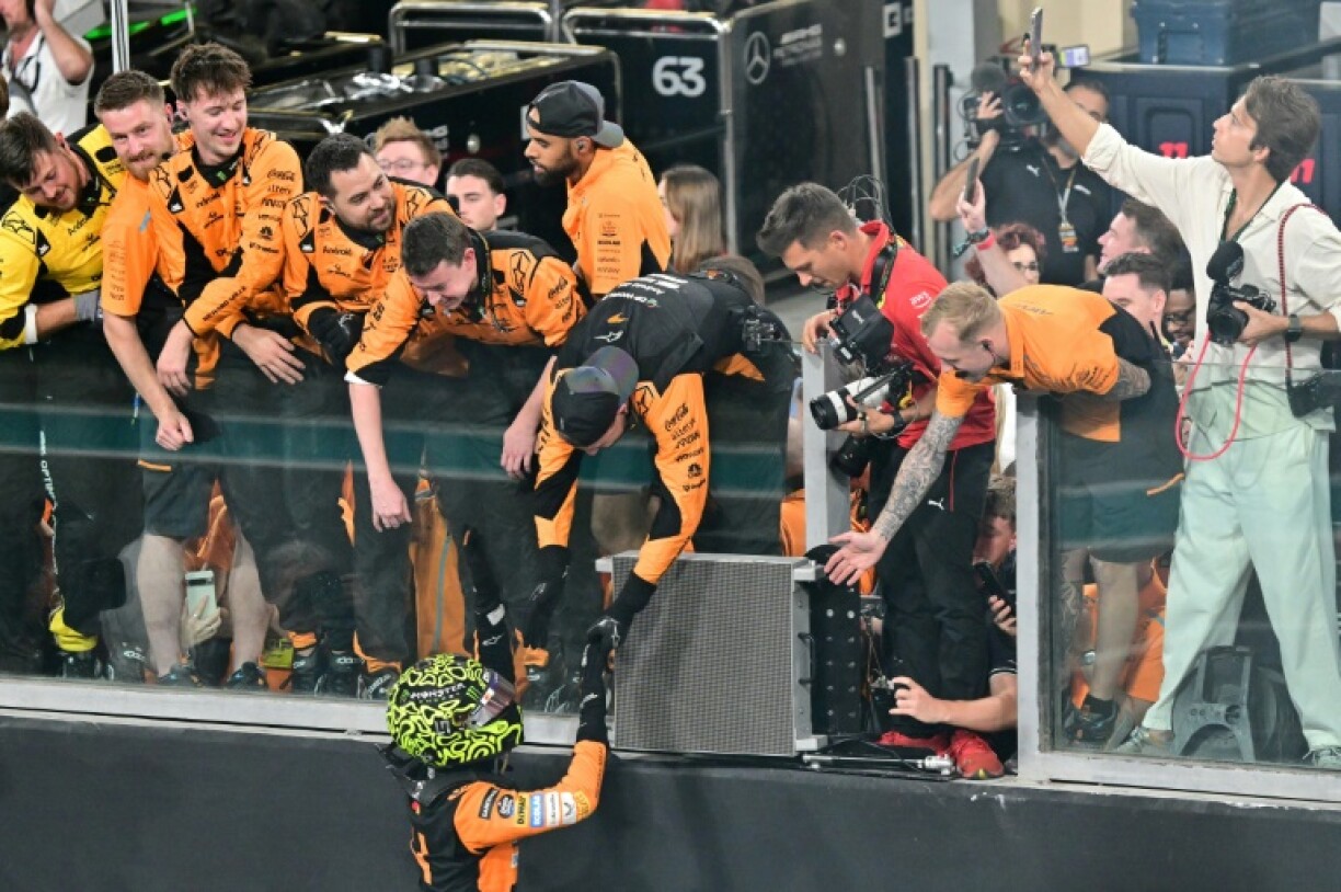 Lando Norris celebrates with the McLaren crew after winning the Abu Dhabi Grand Prix to seal the constructors' title