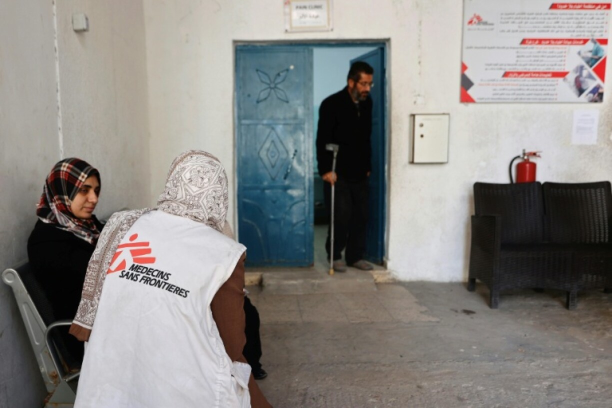 Un membre du personnel de Médecins Sans Frontières (MSF) s'entretient avec une femme qui se rend dans une clinique du quartier d'al-Rimal, à Gaza, la veille du Nouvel An, le 31 décembre 2025