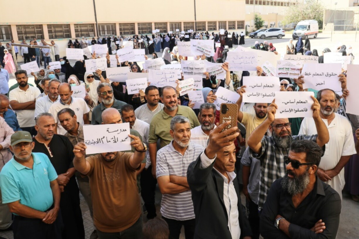 Teachers hold up placards during a demonstration demanding higher salaries and better working conditions at a school in Tripoli on September 29, 2026.