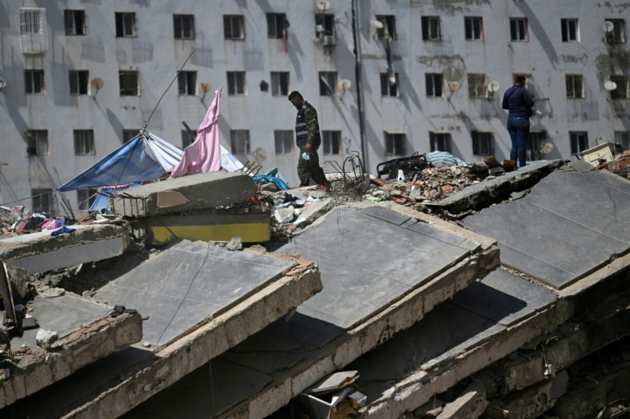 Deux personnes se tiennent au sommet des décombres d'un bâtiment détruit par les séismes du 24 juin à Caraballeda, au Venezuela, le 17 juillet 2026