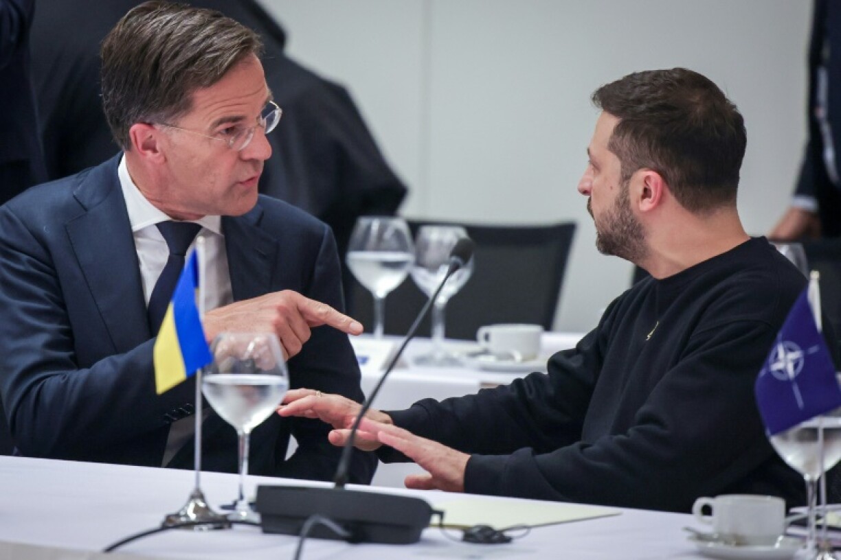 Ukraine's President Volodymyr Zelensky (R) is seeking security guarantees from NATO, headed by Mark Rutte (L) -- but is under