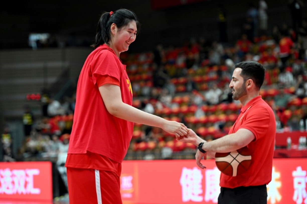 Zhang Ziyu shakes the hand of an umpire prior to the game against Japan