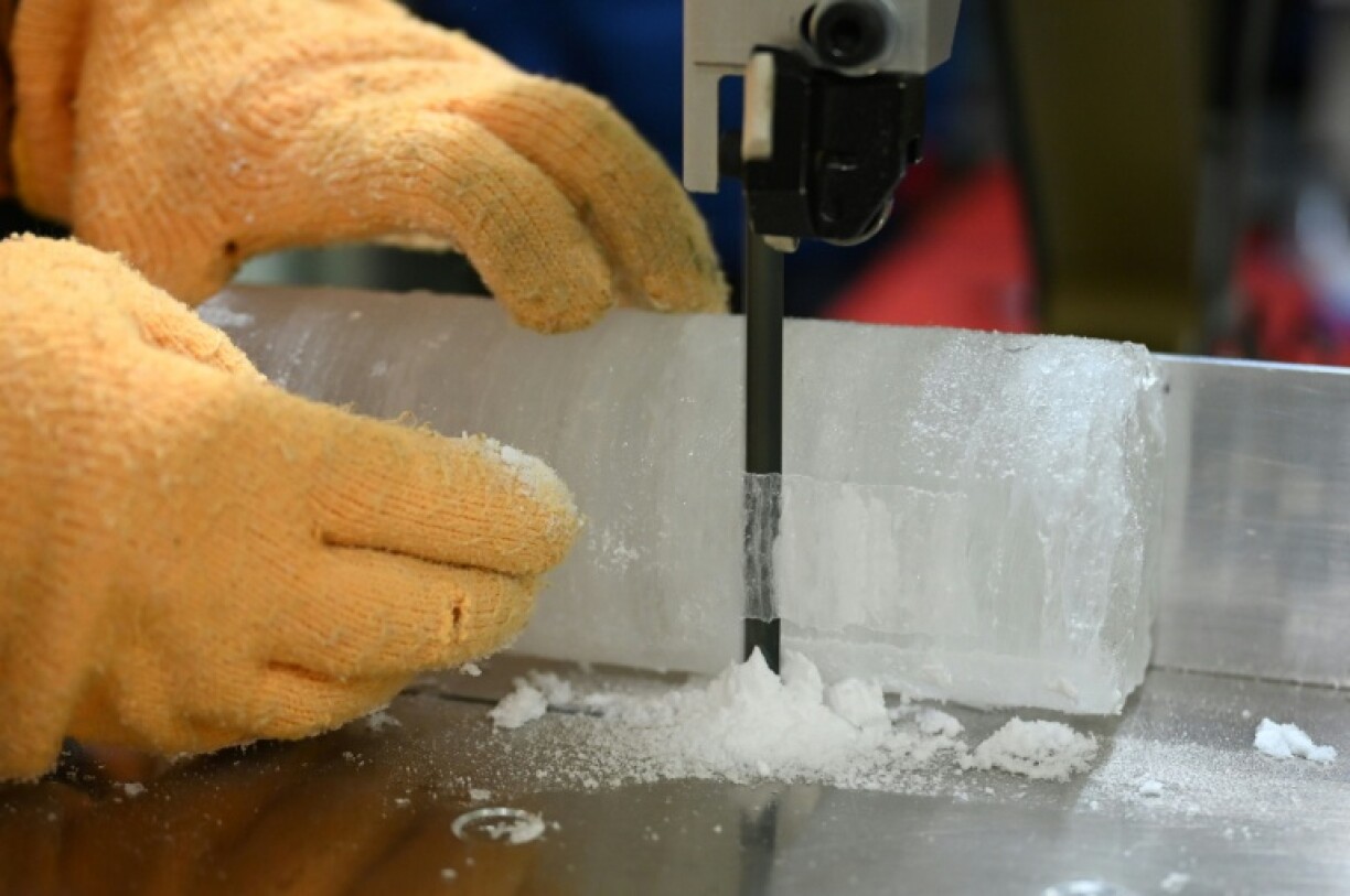 Le professeur Yoshinori Iizuka coupe une tranche d'un échantillon de carotte de glace, à l'Institut des sciences cryogéniques de l'université d'Hokkaido, à Sapporo, au Japon, le 9 décembre 2025