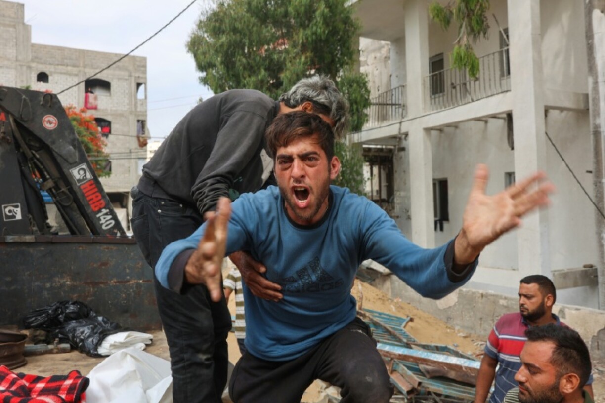 A Palestinian man mourns as others transport bodies of people killed in Israeli strikes on Jabalia a day earlier