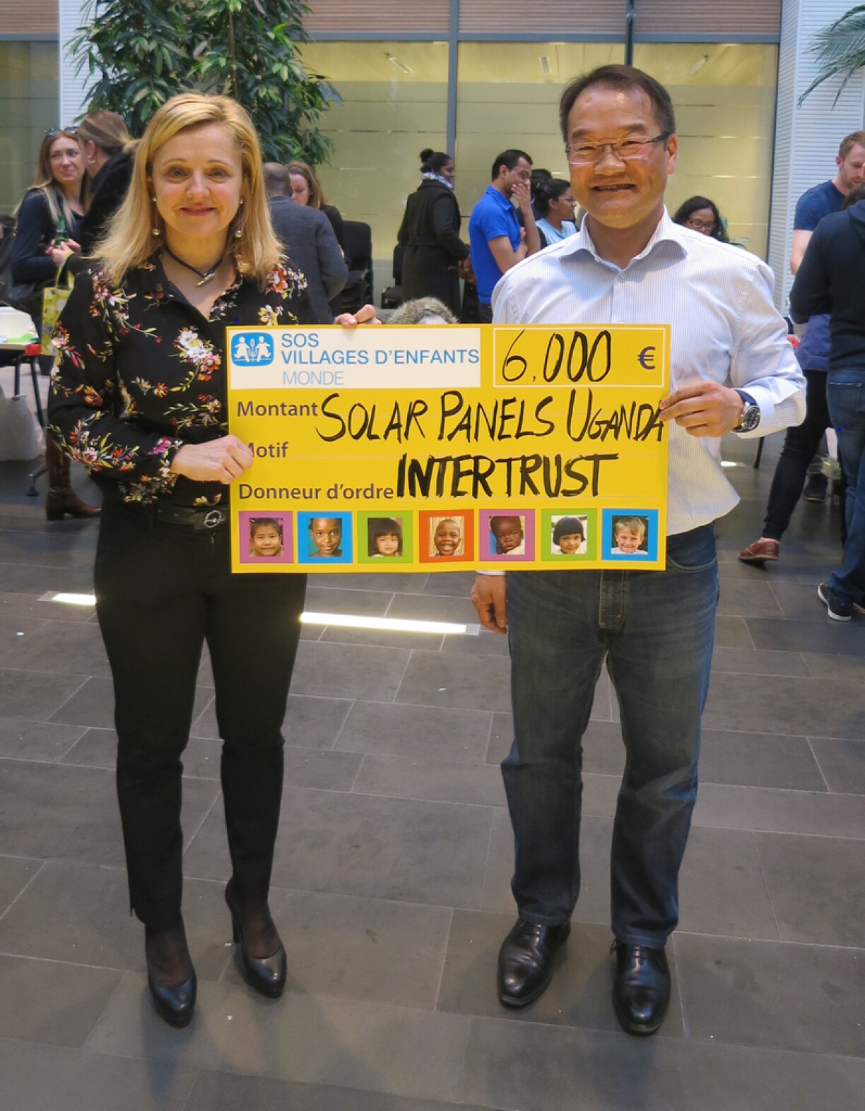 Stéphane Toscano, Directeur des Ressources Humaines d'Intertrust Luxembourg, remet un chèque à Sophie Glesener, Directrice de SOS Villages d'Enfants Monde.